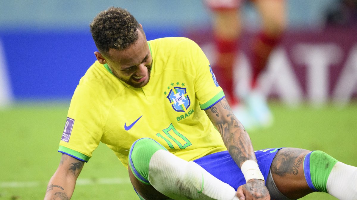Neymar, seleccionado brasileño, se toma si tobillo lesionado, en el partido ante Serbia.