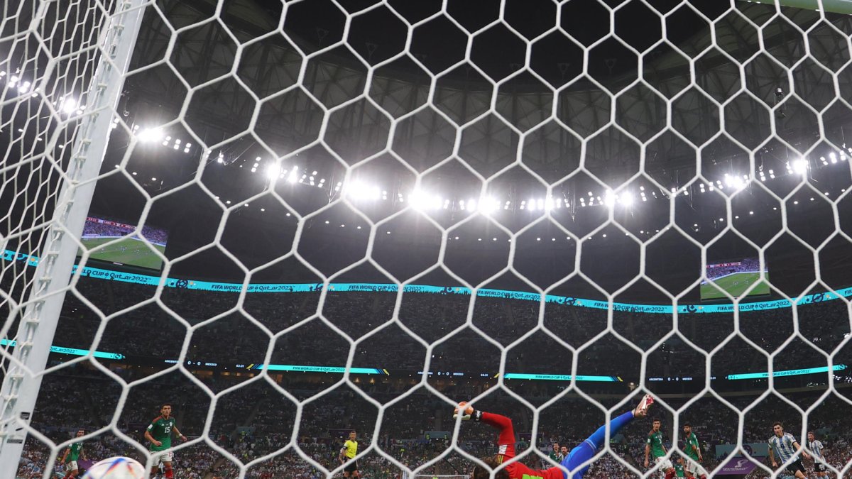 Guillermo Ochoa (abajo) portero de México recibe un gol de Lionel Messi Argentina hoy, en un partido de la fase de grupos del Mundial de Fútbol Qatar 2022 entre Argentina y México en el estadio de Lusail (Catar).