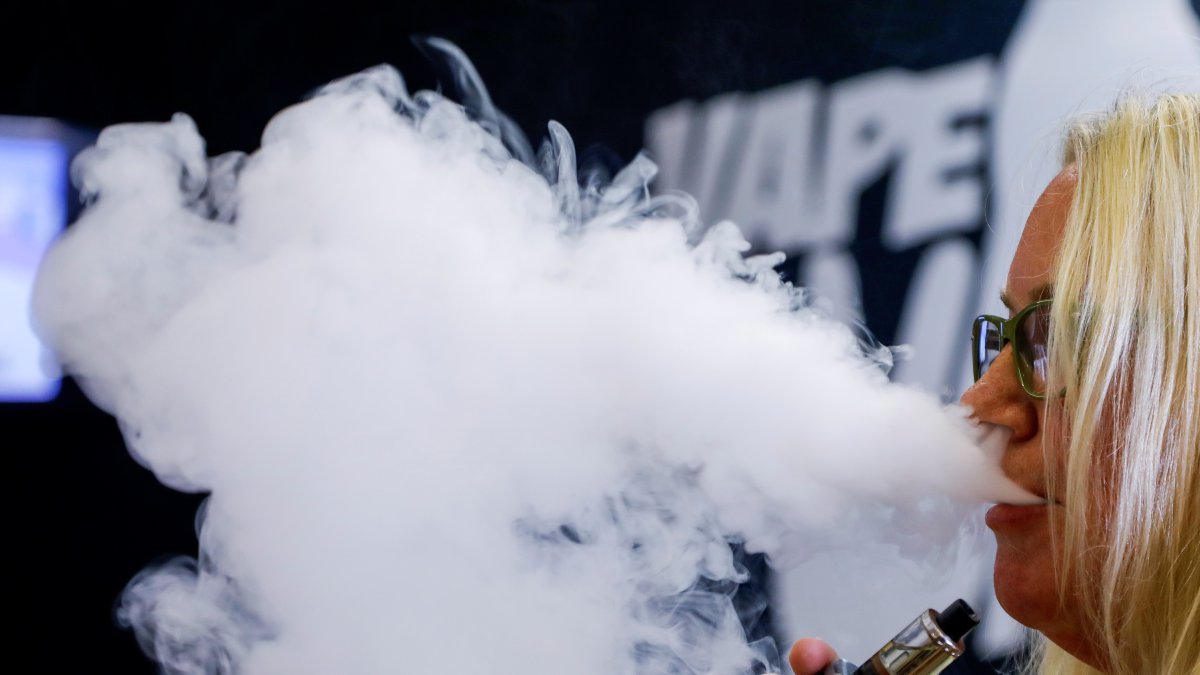 Fotografía de archivo de una mujer consumiendo un cigarrillo electrónico en un comercio especializado en estos productos.