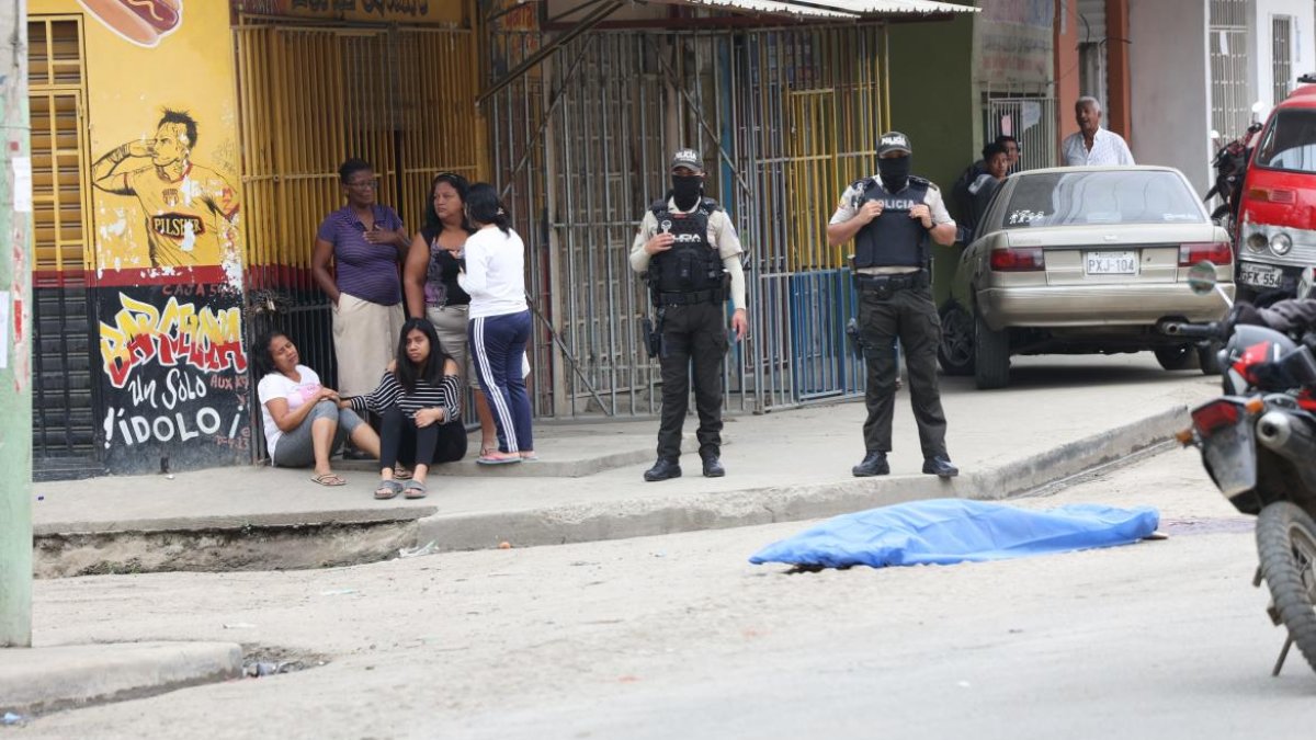 Familiares de una víctima de sicariato lloran a escasos dos metros de su cadáver.
