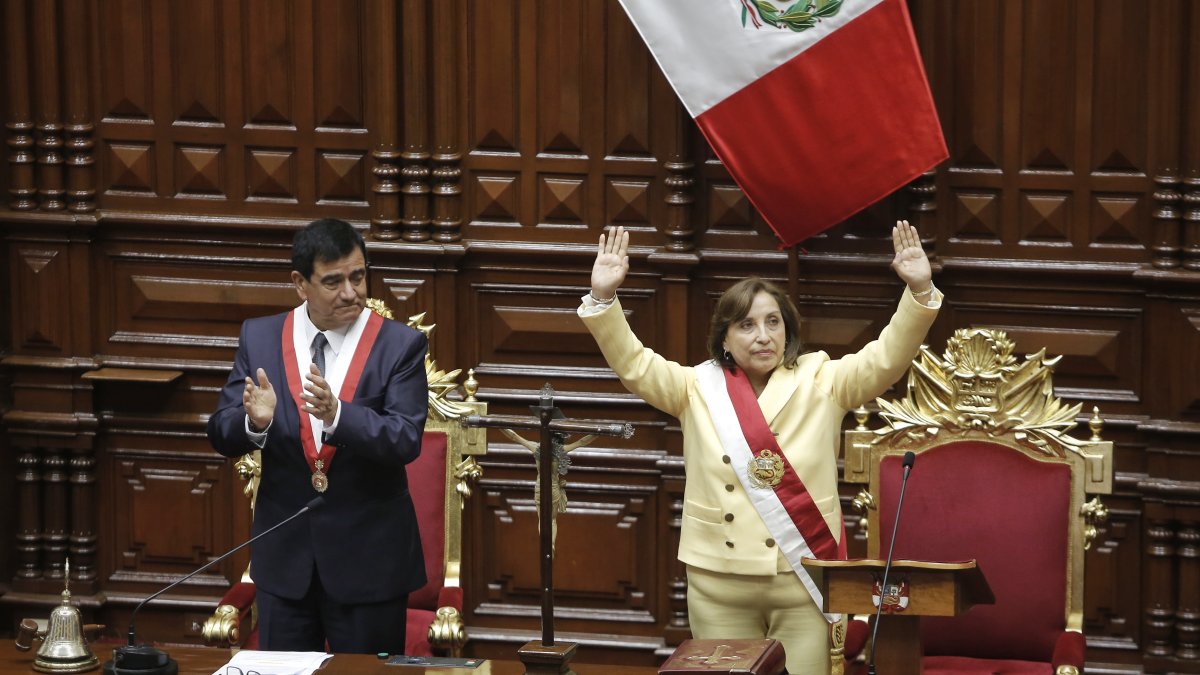 La abogada Dina Boluarte saluda tras ser juramentada como presidenta de Perú  por presidente del Congreso, José Daniel Williams Zapata (i).