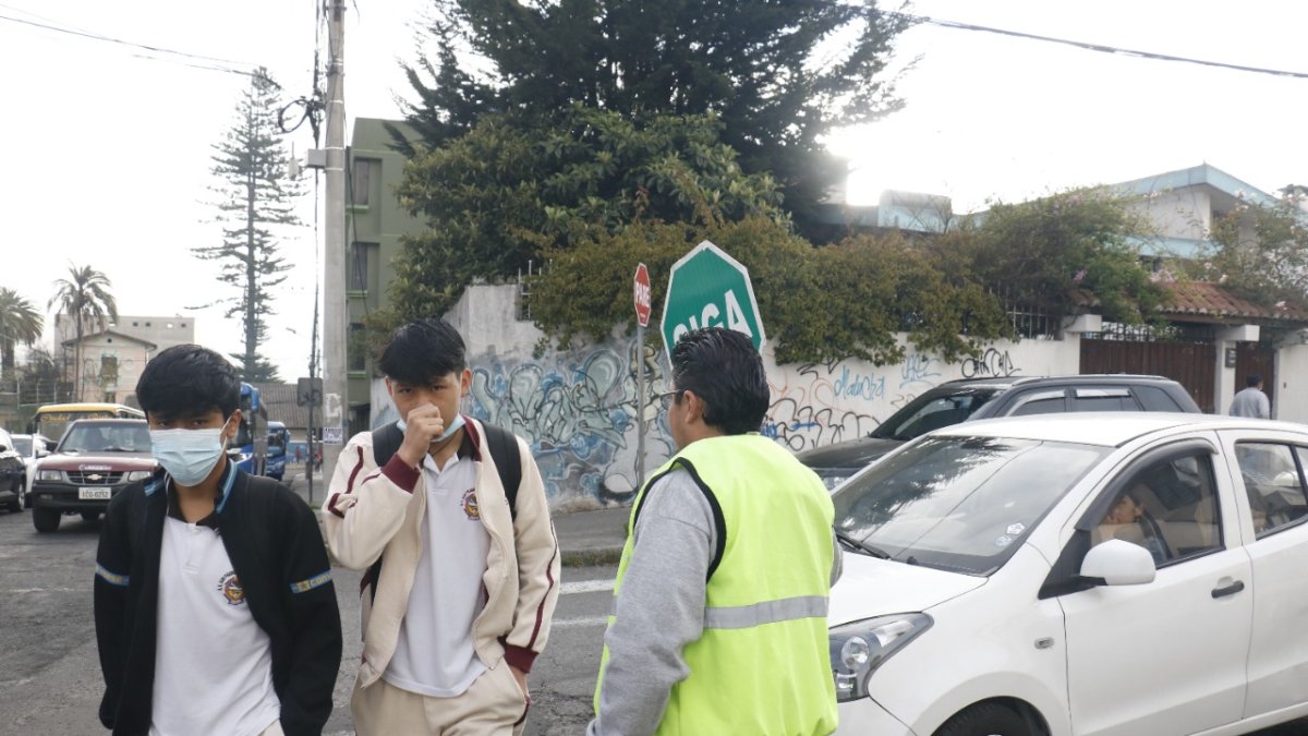 Organización. Los padres deben meterse en el tráfico para mostrar el letrero de ‘pare’ y dar tiempo a los chicos para que crucen la calle.