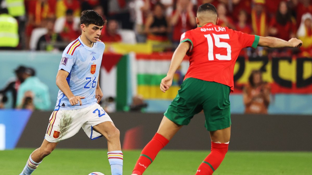 Pedri (i), mediocentro español, en disputa con Selim Amallah, centrocampista marroquí, durante el choque por octavos de final del Mundial de Qatar 2022.