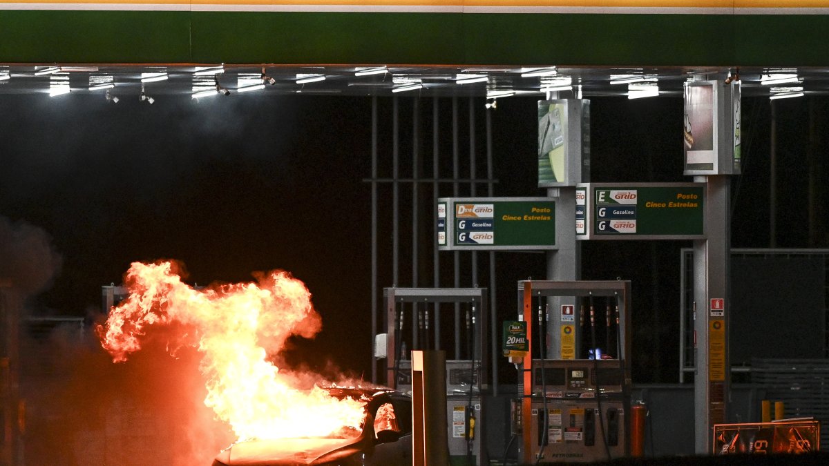 Vista de un vehículo incinerado por seguidores del saliente presidente de Brasil, Jair Bolsonaro, durante el lunes 12 de diciembre de 2022 en una estación de gasolina en Brasilia (Brasil).