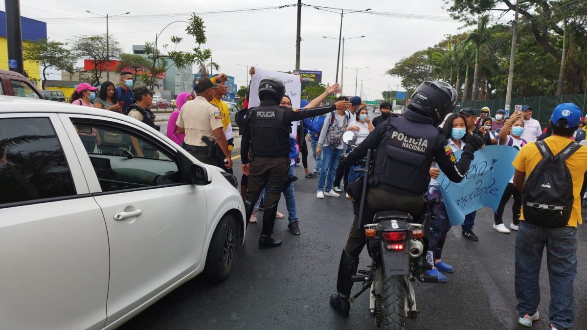 Trabajadores de la empresa Turbo Limpieza, que brinda sus servicios al hospital Teodoro Maldonado Carbo, protestan afuera de la entidad, en la avenida 25 de Julio.