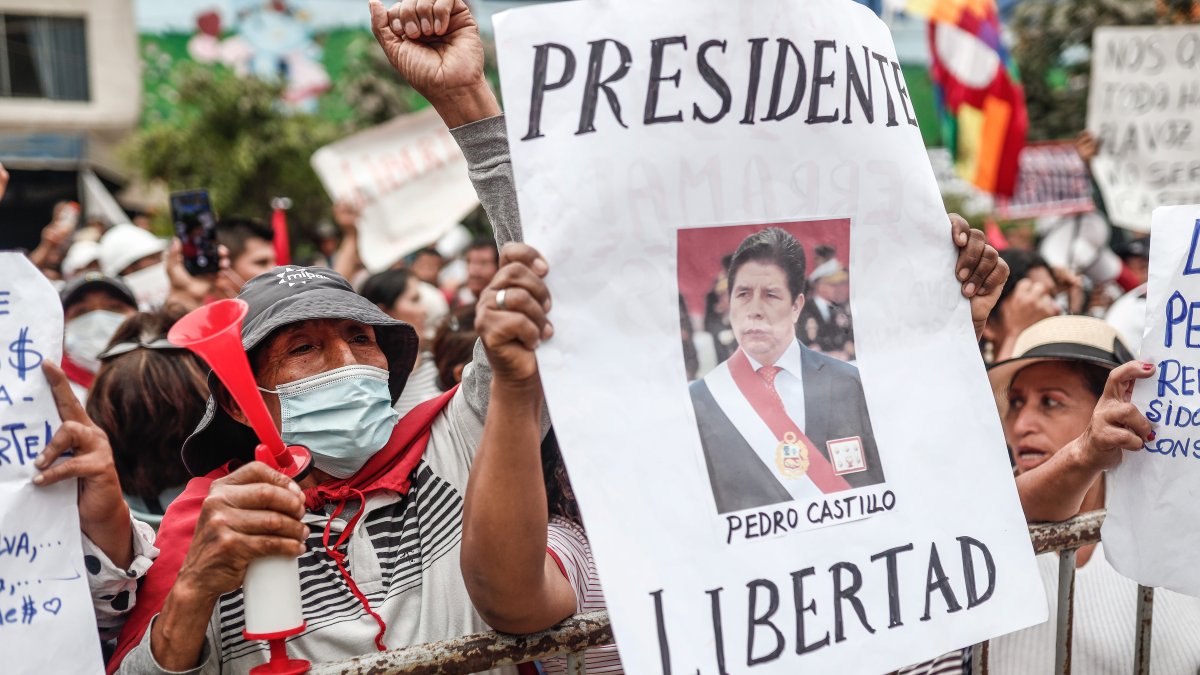 Manifestantes muestran su apoyo hacia el expresidente Pedro Castillo y exigen su libertad hoy jueves 15 diciembre, en fuera del recinto donde está preso, en el distrito de Ate en Lima (Perú).