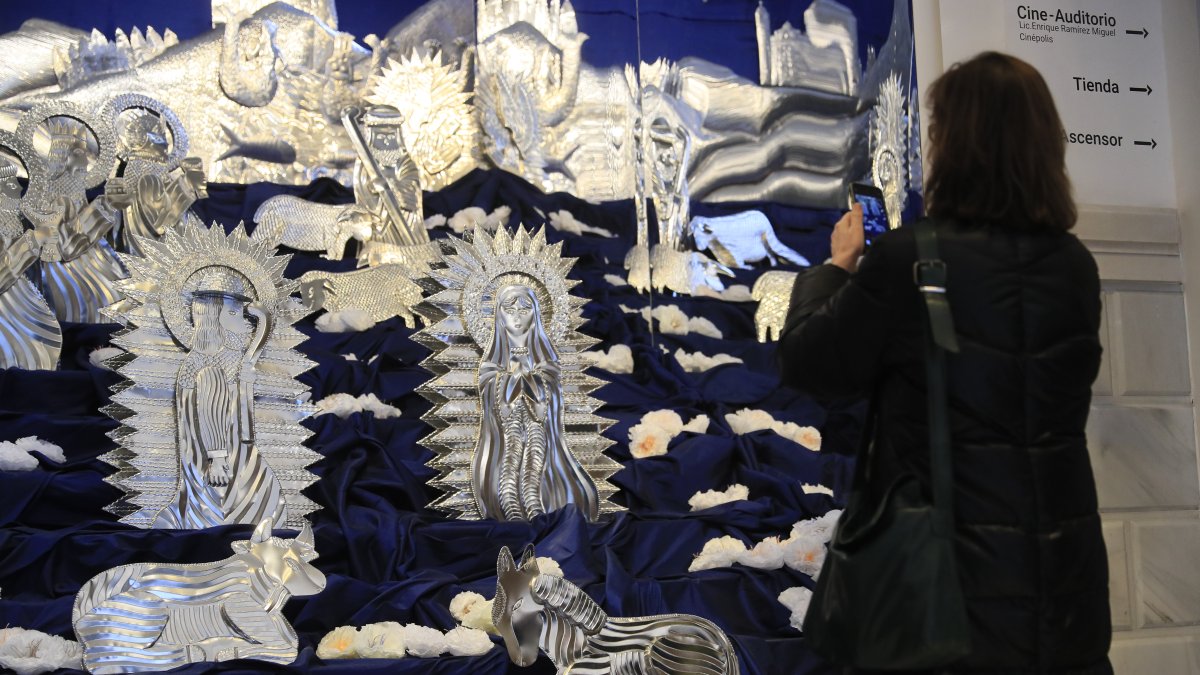 Muestra. Una visitante observa el gran nacimiento de hojalata repujada.