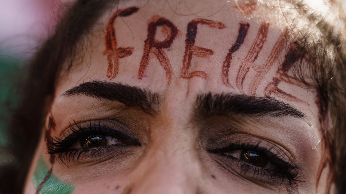 magen de archivo de una manifestante, con la palabra libertad en alemán escrito en el rosto, se solidariza en las calles de Berlín con las mujeres iraníes tras la muerte de la joven Mahsa Amini