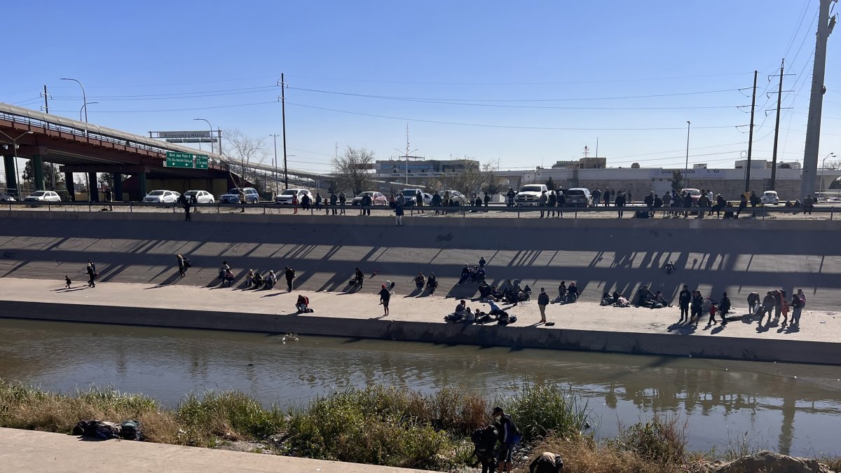 Migrantes esperan para cruzar el río hoy, en la valla fronteriza de El Paso, Texas, frente a Ciudad Juárez, México. EFE/Octavio Guzmán