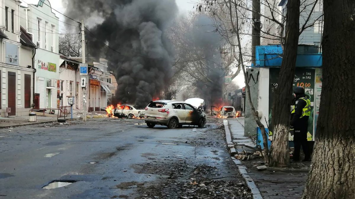 Una foto distribuida por el servicio de prensa del Servicio Estatal de Emergencia (SES) de Ucrania muestra automóviles en llamas en una calle después de bombardeos.