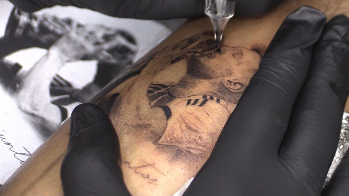 Una persona se hace un tatuaje de Lionel Messi besando la Copa del Mundo, el 20 de diciembre de 2022 en Rosario (Argentina).