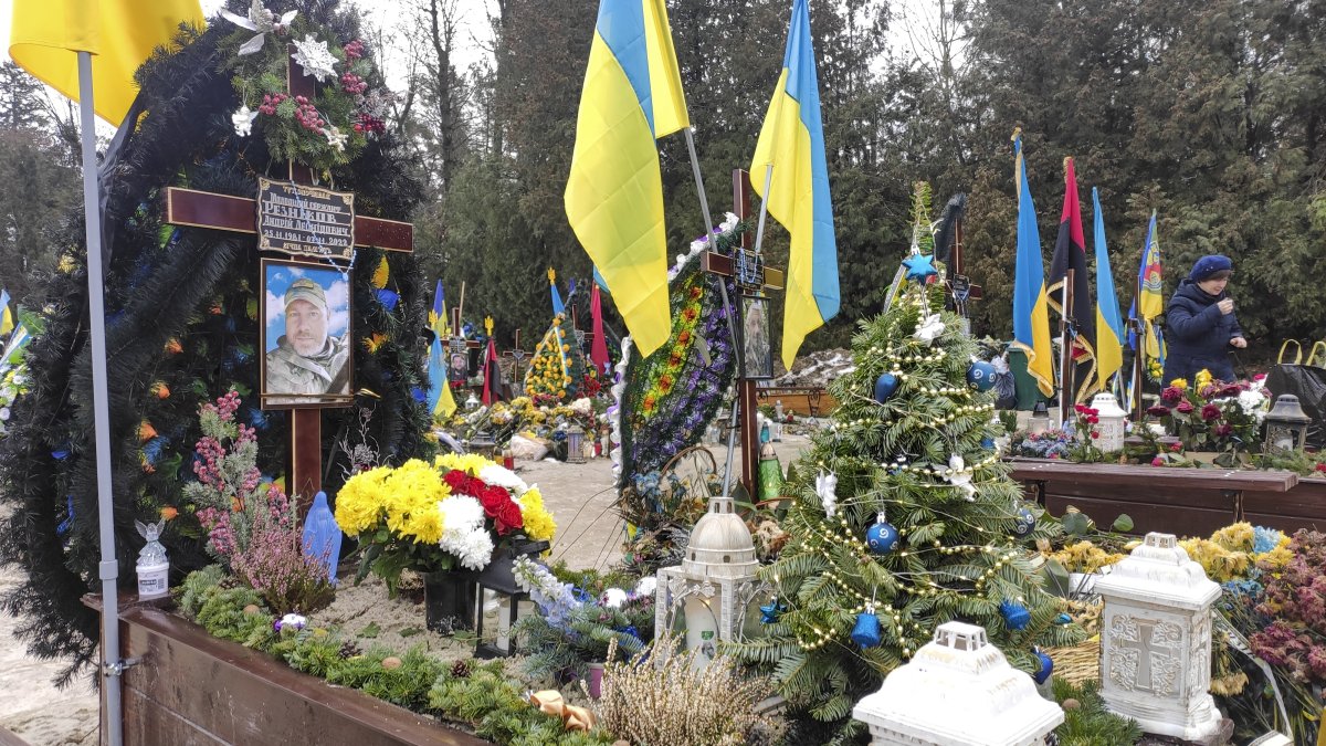 Escena. Las tumbas de los soldados caídos en la invasión rusa a Ucrania aparecen decoradas con árboles de Navidad, este domingo, en un cementerio de Lviv. 
