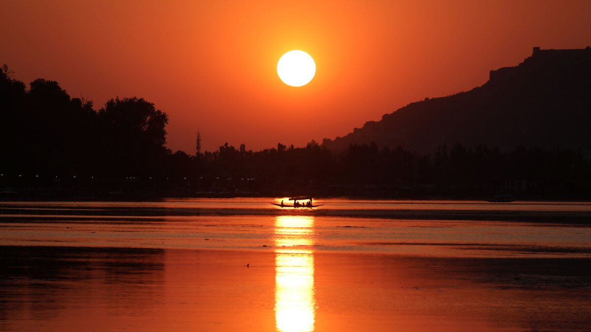 Un hombre de Cachemira rema a través de las aguas del lago Dal mientras se pone el sol en Srinagar, la capital de verano de la Cachemira india, en una imagen de archivo. EFE// 