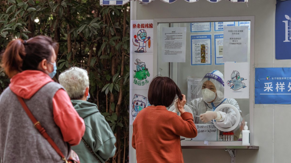 Shanghái. Ciudadanos hacen fila por un test PCR de coronavirus.
