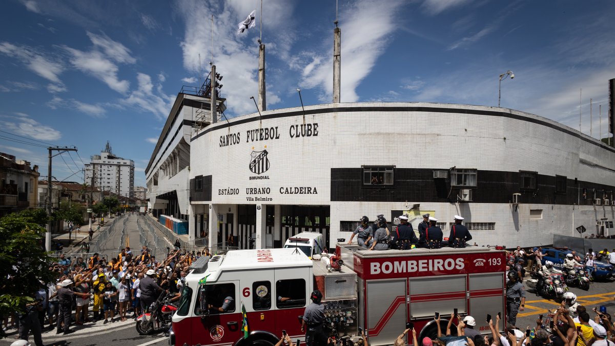 Un camión de bomberos que transporta el féretro con el cuerpo de la leyenda del fútbol Edson Arantes do Nascimento 'Pelé encabeza hoy el cortejo fúnebre que recorrerá algunas calles de la ciudad, rodeado de miles de aficionados, en dirección al cementerio donde será enterrado el tres veces campeón mundial, en Santos (Brasil).