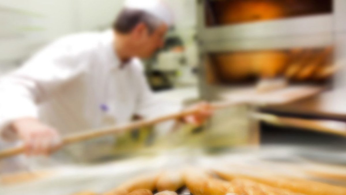 Trabajo.- Un panadero elaborando el pan baguette.