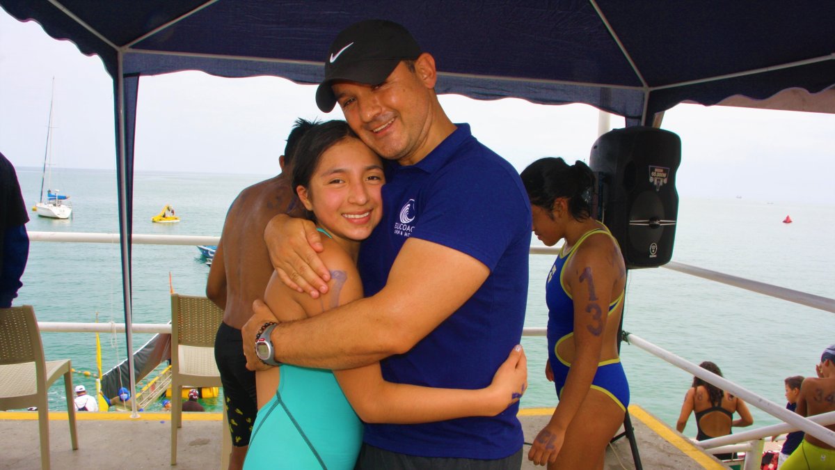 Rafaela Coello, nadadora quiteña, junto a su entrenador Eduardo Sandoval, quien descubrió su talento en el agua.