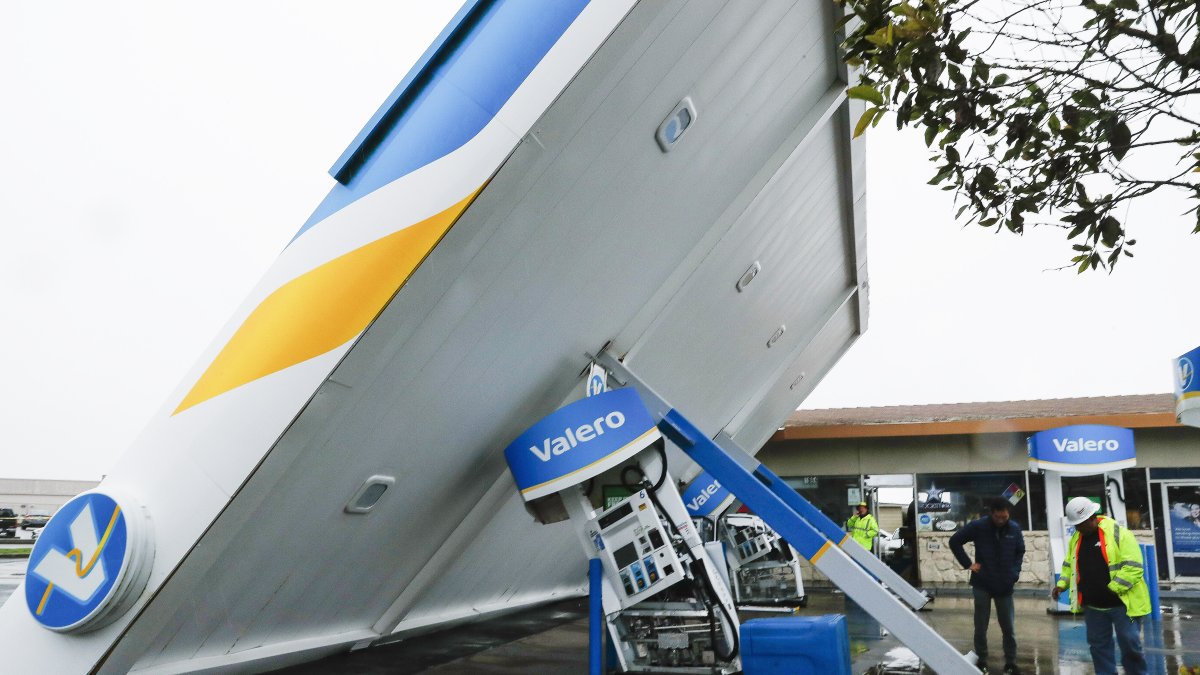 Un trabajador de una estación y uno de servicios públicos revisan los daños en el techo de una estación de servicio Valero en South San Francisco, California, EE. UU. JOHN G. MABANGLO