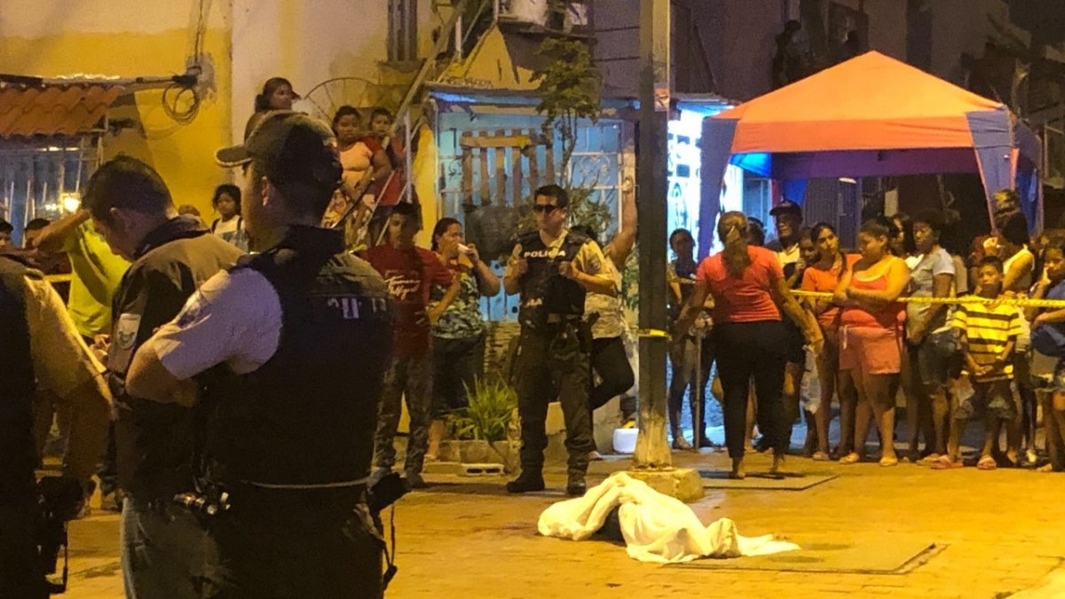 Babahoyo. El cuerpo de la lmujer le dispararon por siete ocasiones mientras salía del reasentamiento Brisa del Río, aparece cubierto con una sábana blanca.