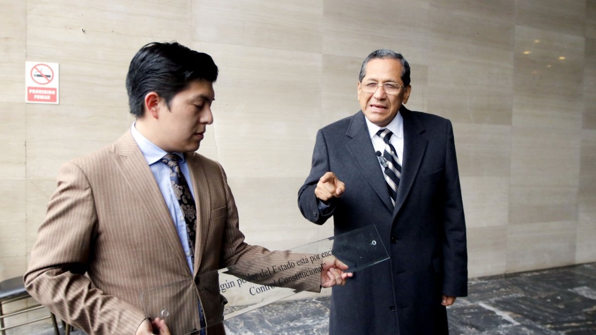 Remoción. El asambleísta Luis Almeida y uno de los asesores de su colega de bancada Pablo Muentes quitan la “placa de la infamia”.