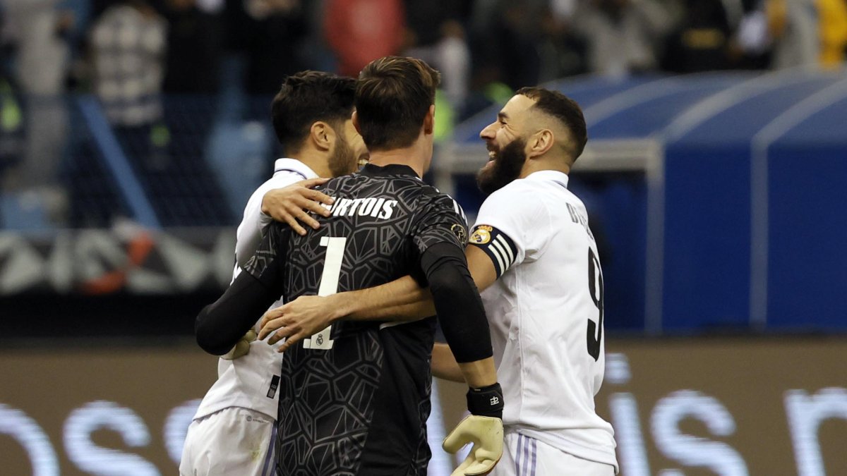 Los jugadores del Real Madrid Marco Asensio (i) y Karim Benzemá (d) felicitan a Thibaut Courtois tras detener el último penalti ante el Valencia.