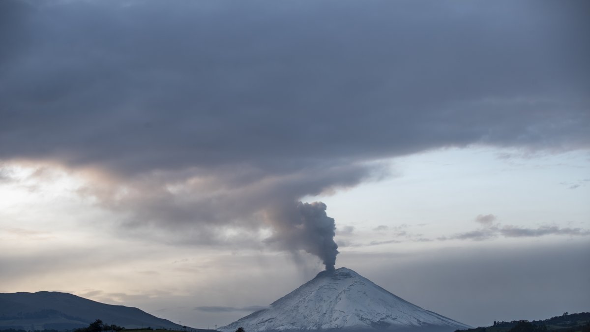 Fotografía del volcán Cotopaxi, con una fumarola de gas y ceniza, visto hoy desde la ciudad de Quito (Ecuador).