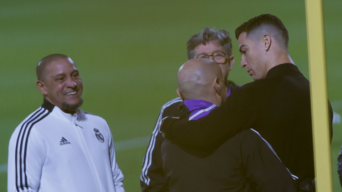 El futbolista portugués Cristiano Ronaldo (d) y el exfutbolista brasileño Roberto Carlos (i) asisten al entrenamiento del Real Madrid.