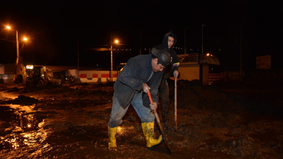 Ciudadanos tratando de limpiar las calles luego del deslave.