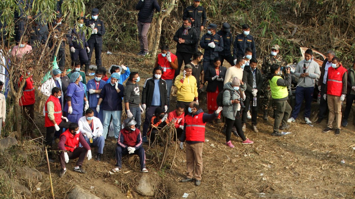 Atención. El equipo de rescate trabajan con los restos del avión siniestrado en el lugar del accidente este domingo en Pokhara, Nepal.