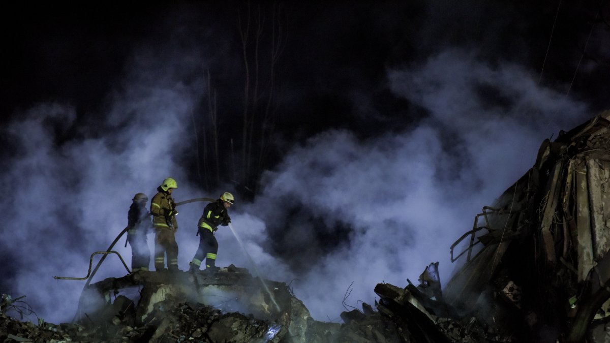 Un equipo de rescate trabaja sin descanso entre los escombros del edificio residencial dañado en Dnipró, sureste de Ucrania, / 