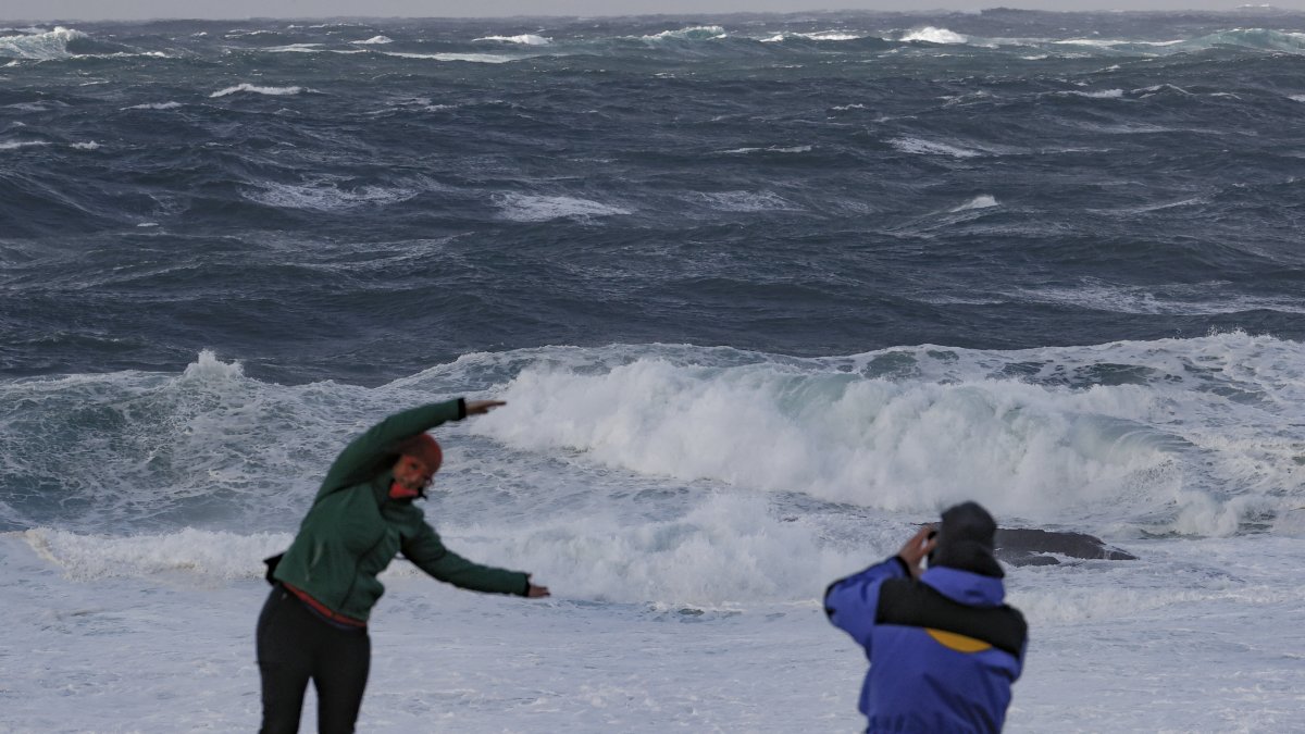 Los turistas observan el fuerte oleaje  en la costa de Muxía, en la Costa de la Muerte. Tras el paso  de la borrasca  FEE jr