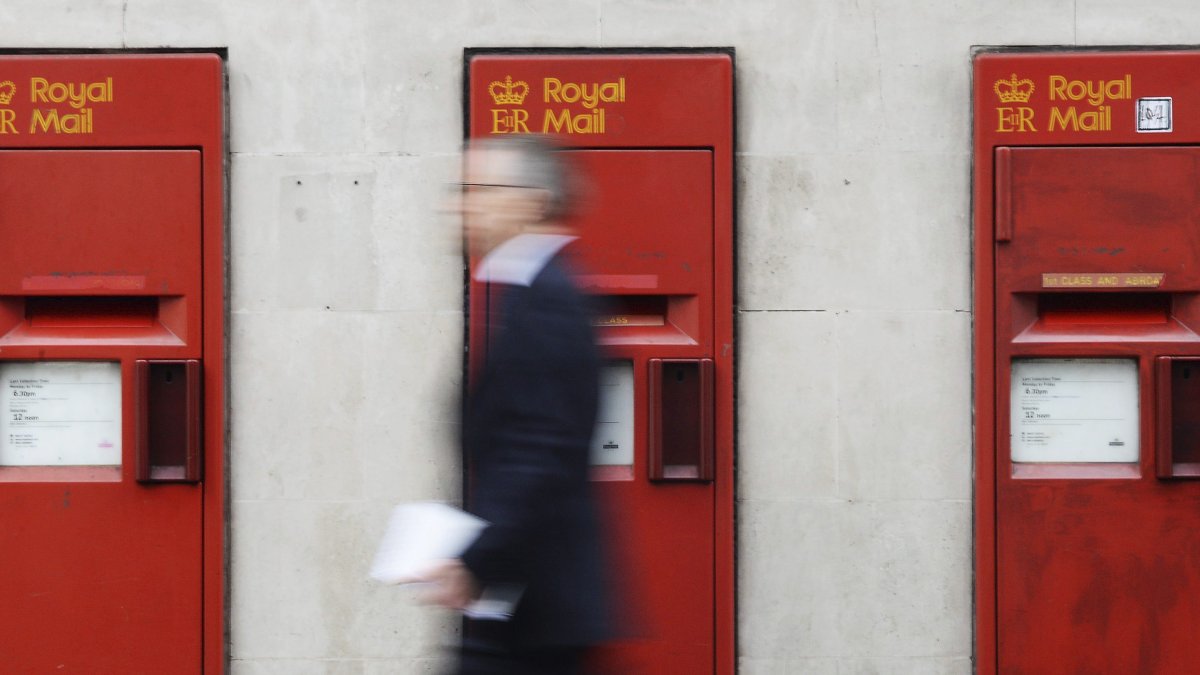 Un peatón pasa por los buzones de correo de Royal Mail en Londres el 25 de marzo de 2014. /