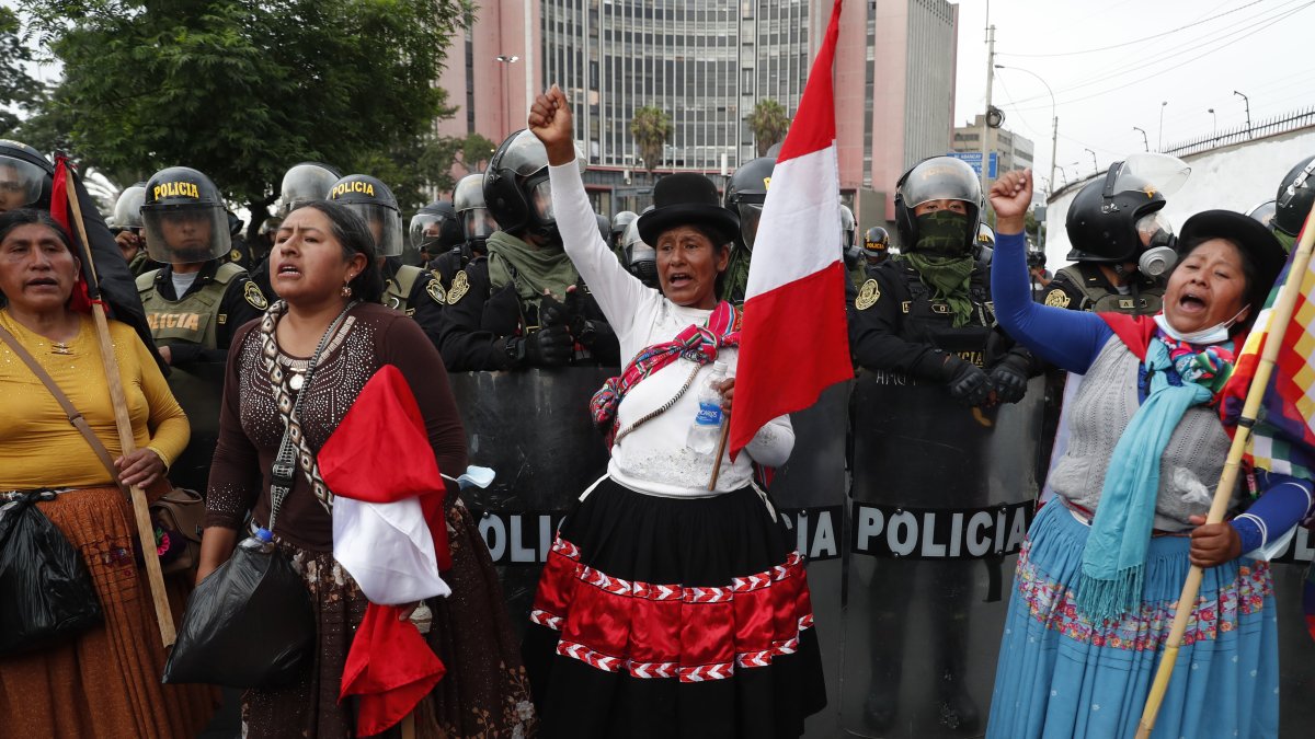 Manifestantes participan en una marcha bloqueada por policías y que se dirigía al Congreso, hoy viernes 20 de enero,   en Lima (Perú).  