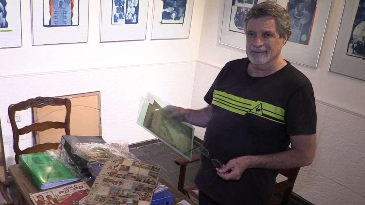 Caso. El dibujante y escultor argentino Julio Rayón posa con varios de los álbumes de cromos que colecciona.