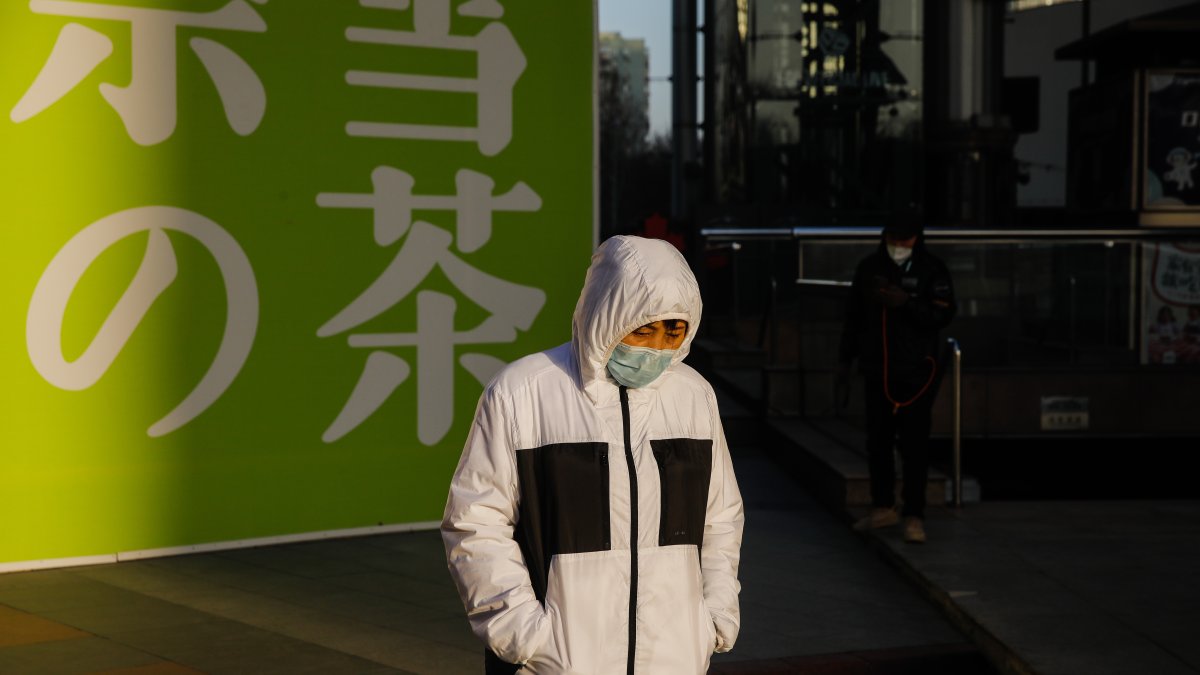Una mujer con mascarilla camina por la calle en Pekín el 16 de enero de 2023. EFE/EPA/WU HAO