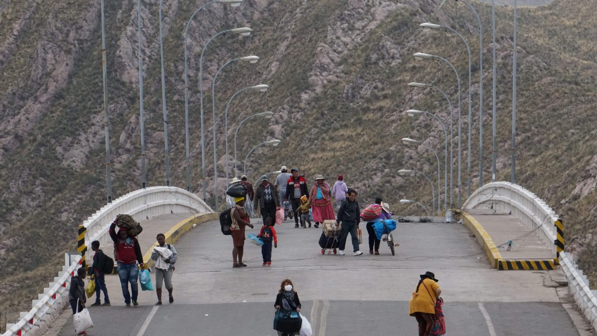 Fronteras. Varias personas cruzan a pie la frontera entre Bolivia y Perú, debido a las protestas sociales, en la población de Desaguadero.