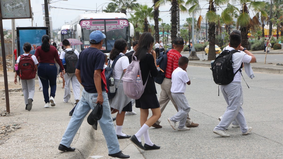 Los estudiantes de la escuela Rosita Paredes atraviesan corriendo los parterres de la avenida Francisco de Orellana.