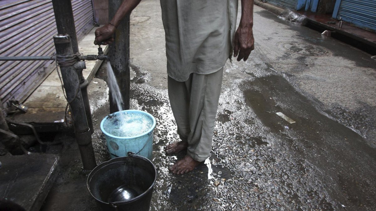 Un hombre llena unos cubos de agua en una fuente en un mercado en Amritsar (India), en una fotografía de archivo.