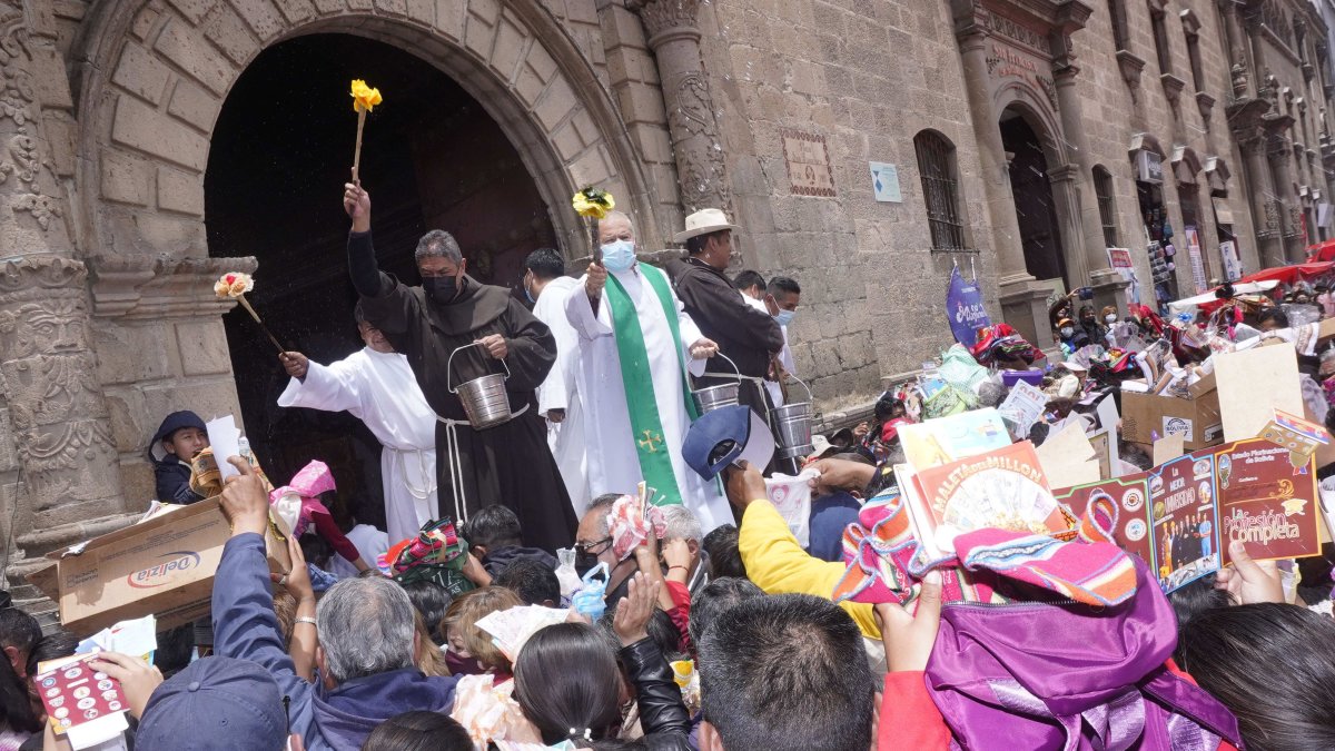 La Paz. Sacerdotes bendicen a personas que llevan miniaturas compradas en la Alasita, la fiesta boliviana de la prosperidad y la abundancia.