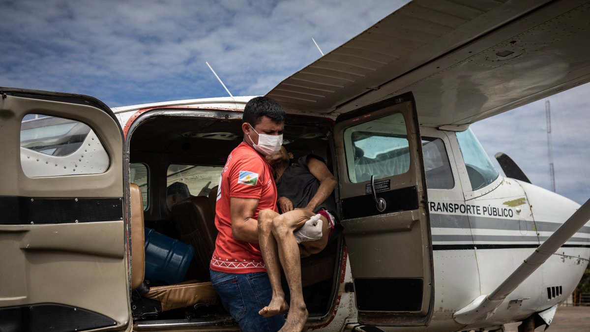 Una mujer yanomami con malaria grave y señales de desnutrición recibe asistencia al llegar en un avión en un aeropuerto en la ciudad de Boa Vista, hoy en la capital de Roraima, (Brasil)
