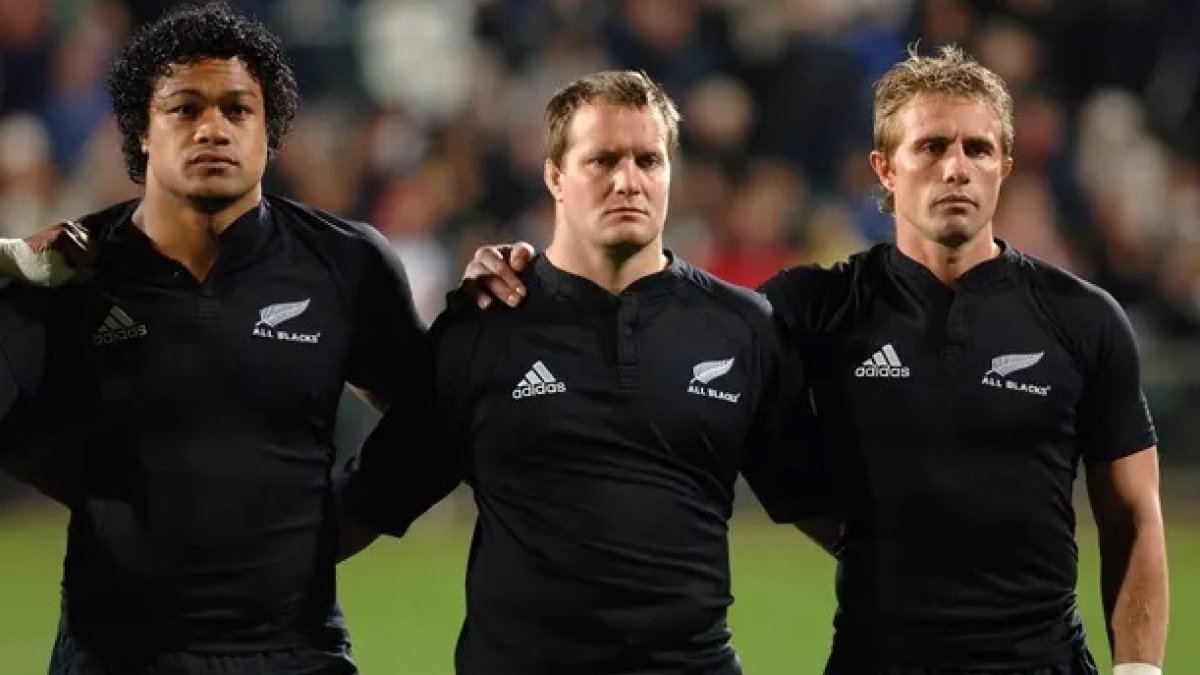 Campbell Johnstone (c) con dos de los integrantes del equipo cuando vestía la camiseta.