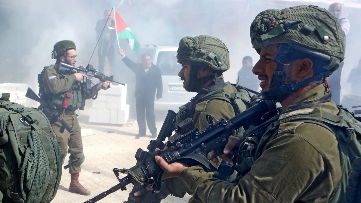 Fotografía de archivo de soldados israelíes lanzando bombas de gas lacrimógeno a un grupo de manifestantes palestinos. EFE/Abed Al Hashlamoun