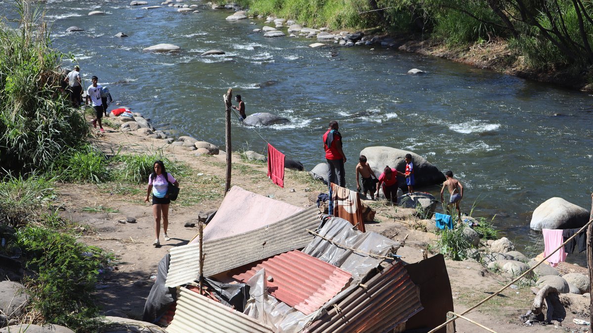 Grupos de personas migrantes se establecen en un campamento improvisado a orillas del Río Coatán hoy, en la ciudad de Tapachula, estado de Chiapas (México). EFE/Juan Manuel Blanco