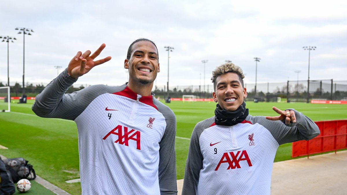 El central Virgil Van Dijk (i) junto a su compañero Roberto Firmino, sonríen durante una práctica del Liverpool.