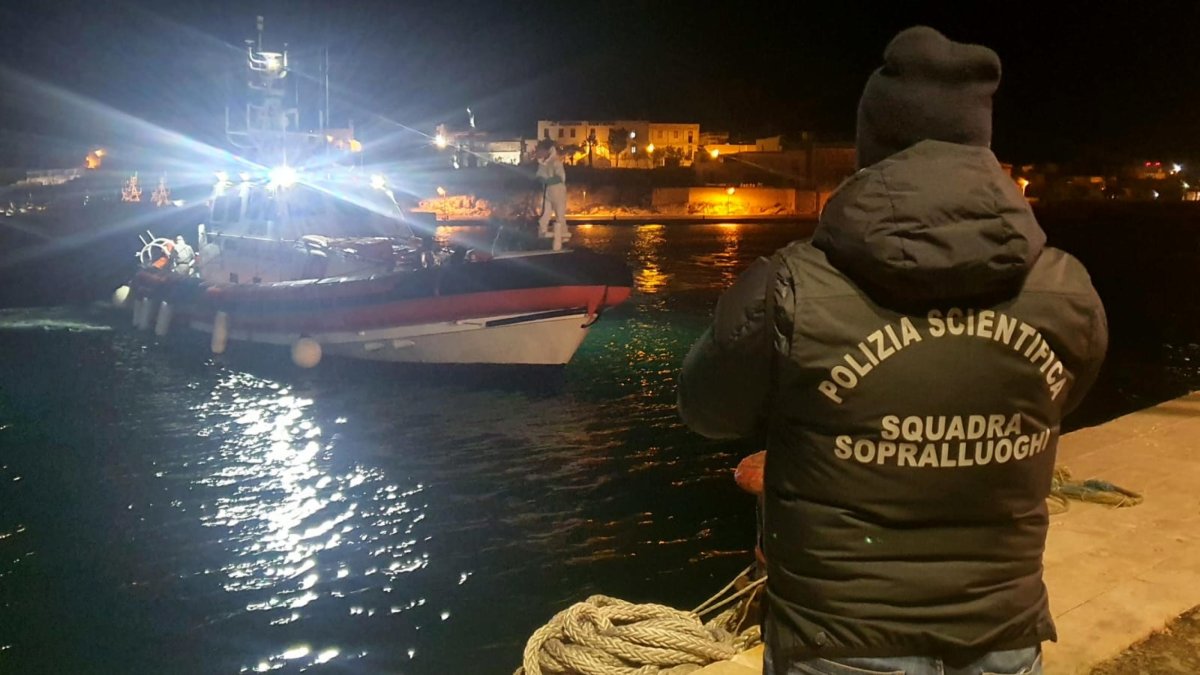 Policías en el muelle del puerto esperan la embarcación con los cuerpos de 8 migrantes en Lampedusa, Sicilia, Italia. EFE/