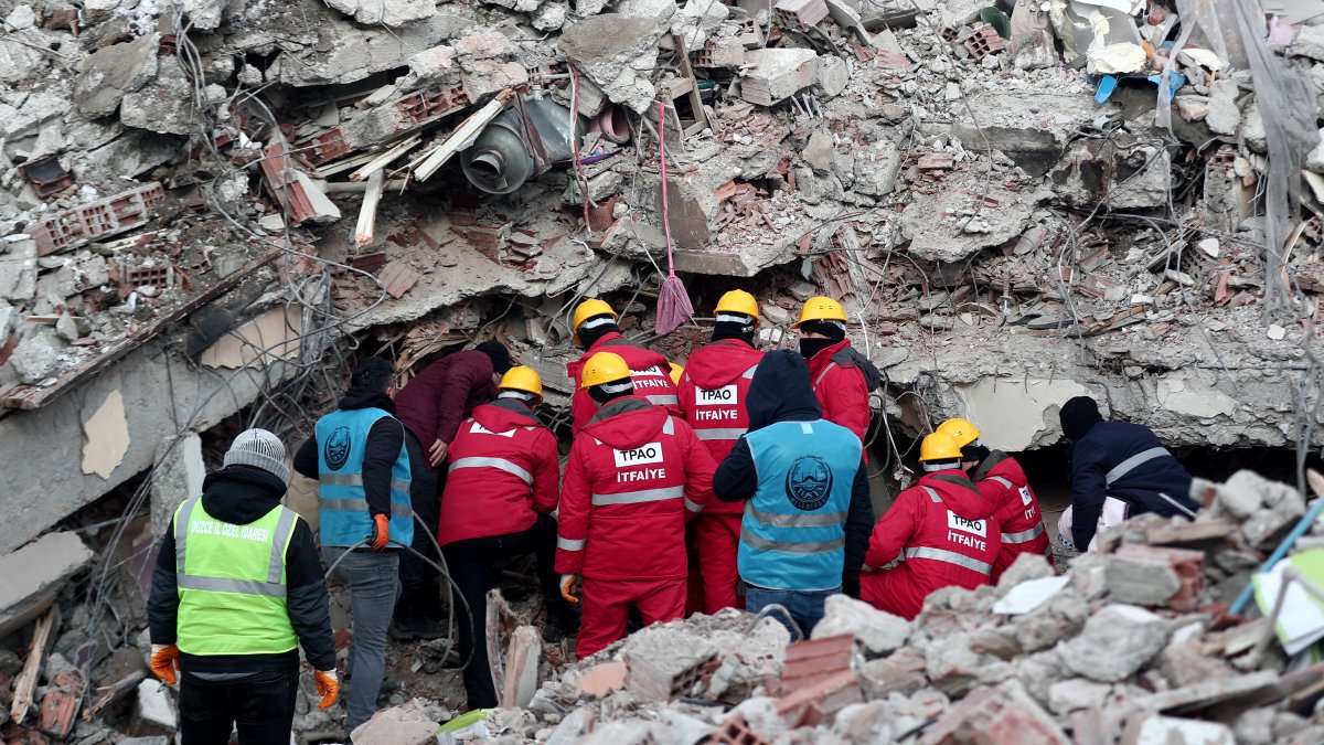 Personal de emergencia y lugareños buscan víctimas en el lugar de un edificio derrumbado tras un fuerte terremoto en el distrito de Elbistan de Kahramanmaras, sureste de Turquía