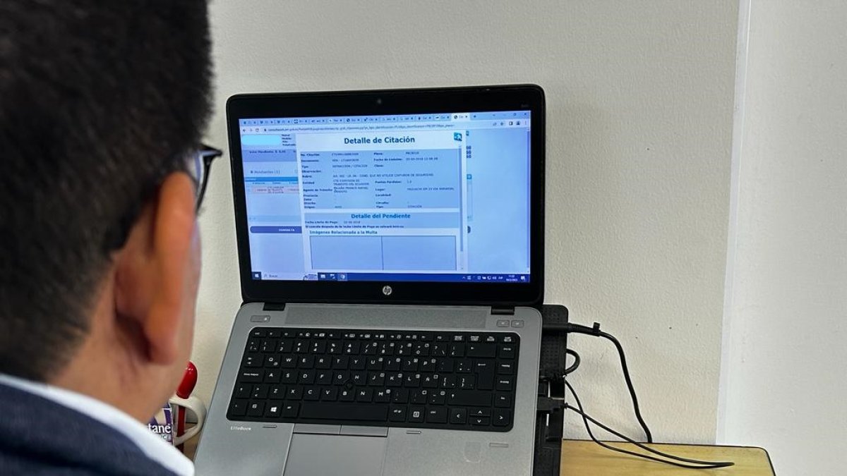 Revisión. Un joven verifica que se haya subido al sistema la multa que recibió en Naranjal