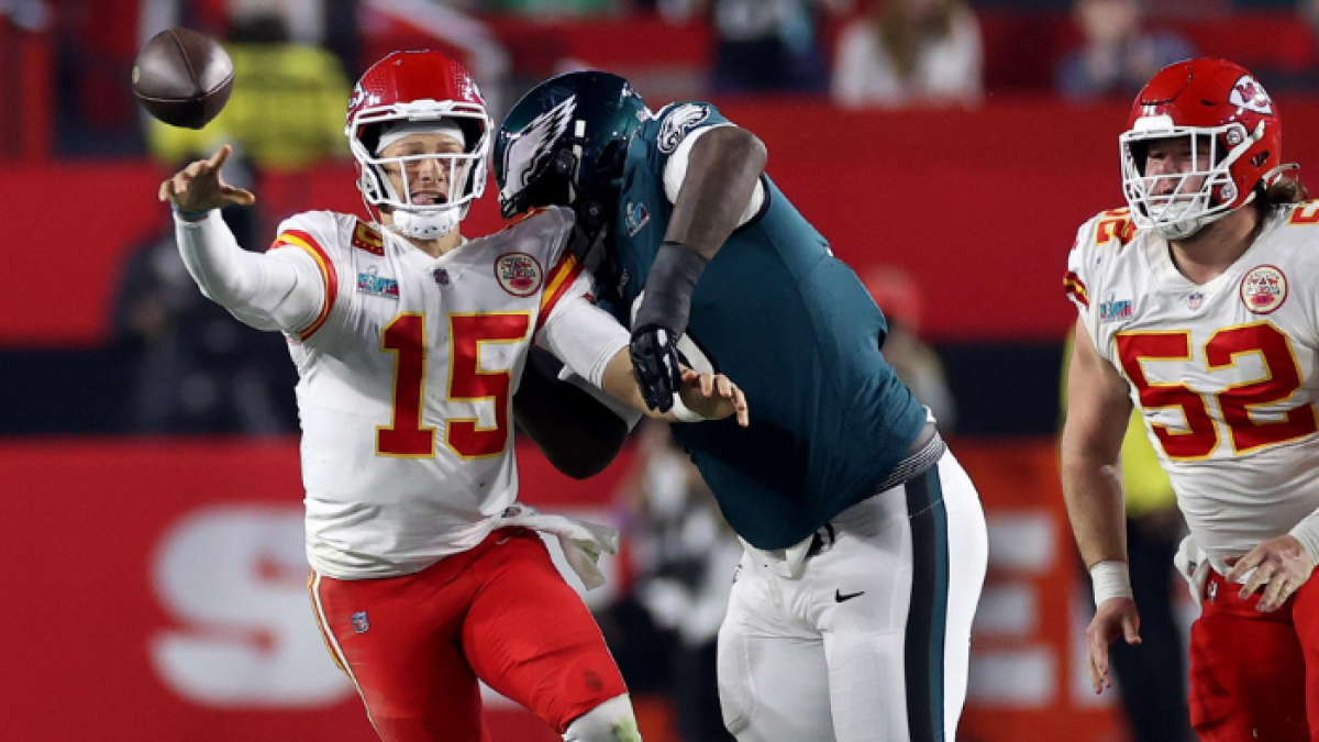 El mariscal de campo de los Kansas City Chiefs, Patrick Mahomes (izq.), pasa bajo la presión del tackle defensivo de los Philadelphia Eagles, Jordan Davis (der.).