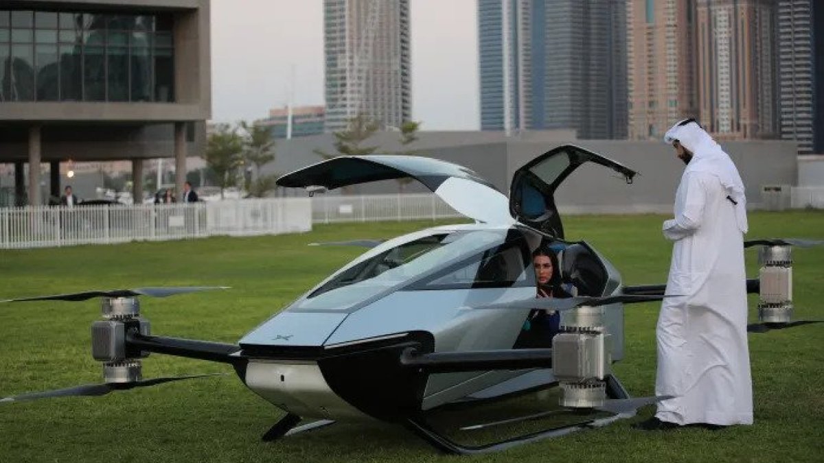 Arabes inspeccionan el auto volador eVTOL durante su exhibición en la Exposición de tecnología de la información del Golfo