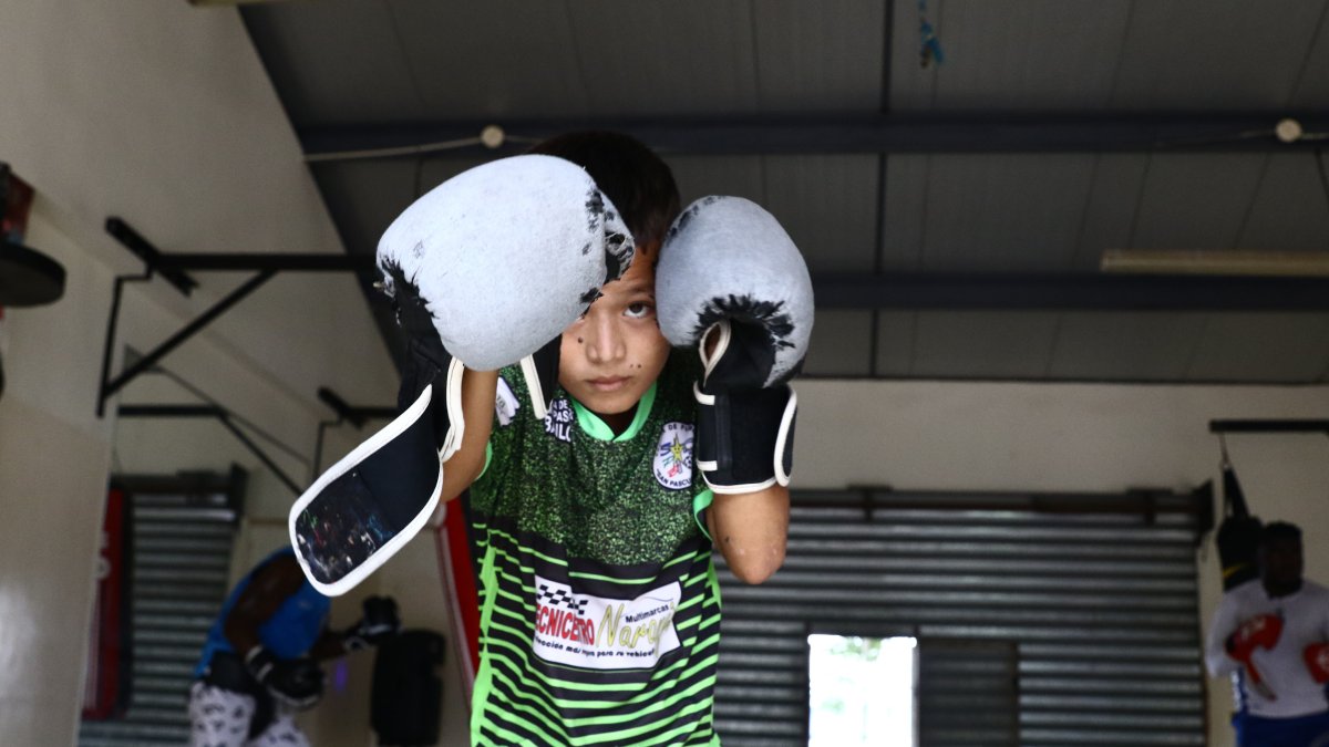 Julián Robles, de 8 años,  entrena en Trinibox con guantes más grandes y gastados.